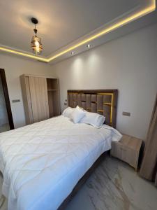 a bedroom with a large bed with white sheets at 1 apartment de luxe hay almatar in Nador
