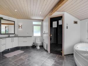 uma casa de banho com um WC, um lavatório e uma banheira em Holiday Home Arny - 1-5km from the sea in NE Jutland by Interhome em Ålbæk