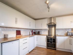 a kitchen with white cabinets and a stove at The Mouries in Fochabers