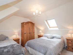 a attic bedroom with two beds and a window at The Mouries in Fochabers