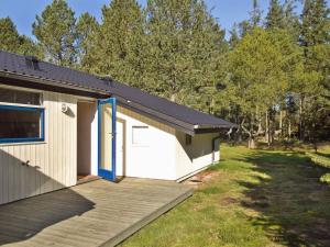 een huis met een houten terras naast een tuin bij Holiday Home Hakan - all inclusive - 4km from the sea by Interhome in Ålbæk