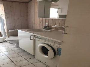 een badkamer met een wasmachine en een wastafel bij Holiday Home Hakan - all inclusive - 4km from the sea by Interhome in Ålbæk
