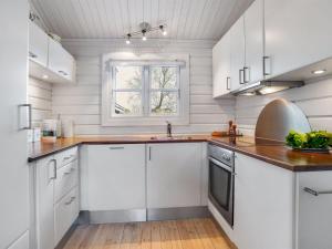une cuisine avec des placards blancs et une fenêtre dans l'établissement Holiday Home Dorthea - 200m from the sea in NE Jutland by Interhome, à Jerup