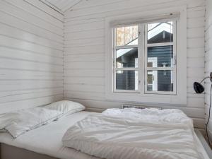 een wit bed in een kamer met een raam bij Holiday Home Dorthea - 200m from the sea in NE Jutland by Interhome in Jerup
