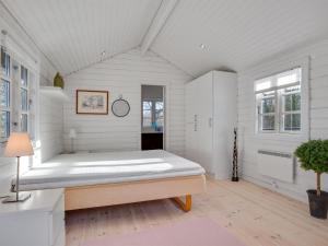 een slaapkamer met een groot bed in een witte kamer bij Holiday Home Dorthea - 200m from the sea in NE Jutland by Interhome in Jerup