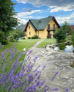 a house with purple flowers in front of it at APARTAMENTY Adamcykówka blisko Velo Czorsztyn, Velo Dunajec ! Jacuzzi i Sauna w cenie! in Kluszkowce