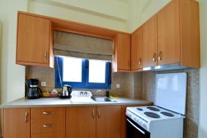 a kitchen with wooden cabinets and a white stove top oven at Kimothoy in Armenistis