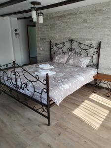 a large bed in a bedroom with a brick wall at Rooms Poienita in Slănic-Moldova