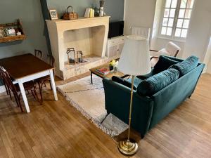 un soggiorno con divano verde e tavolo di La maison de la tour a Apremont