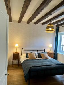 ein Schlafzimmer mit einem Bett mit zwei Tischen und zwei Lampen in der Unterkunft La maison de la tour in Apremont