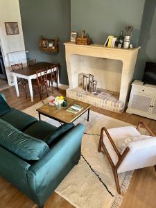 un soggiorno con divano verde e camino di La maison de la tour a Apremont