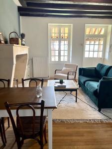 ein Wohnzimmer mit einem Sofa und einem Tisch in der Unterkunft La maison de la tour in Apremont