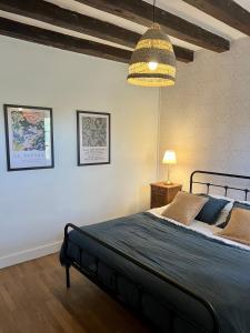 ein Schlafzimmer mit einem großen Bett und einer Lampe in der Unterkunft La maison de la tour in Apremont