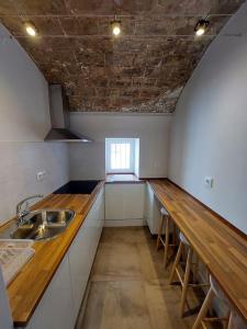 uma cozinha com um lavatório e uma bancada de madeira em New! Estudio La Casita de Arcos em Arcos de la Frontera