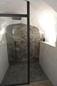 uma casa de banho com um chuveiro e uma parede de pedra em New! Estudio La Casita de Arcos em Arcos de la Frontera