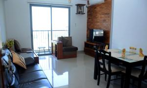 sala de estar con sofá, mesa y TV en Lotus View Apartment Colombo en Colombo