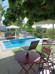 einen Tisch und Stühle neben einem Pool in der Unterkunft PAP'S Chambres d'Hôtes in Mahajanga