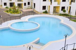 a large pool with blue water in front of a building at Alloggio in Isca sullo Ionio