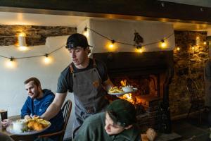 twee mannen aan een tafel met borden eten bij Royal Oak in Cartmel