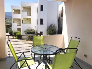 a glass table and chairs on a balcony at Alloggio in Isca sullo Ionio