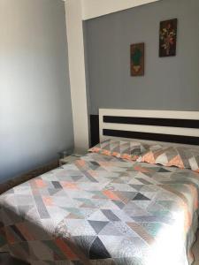 1 dormitorio con 1 cama con edredón en Apartamento Elizabetta 3, pé na areia, en Arraial do Cabo