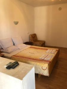 ein Schlafzimmer mit einem großen Bett und einem Stuhl in der Unterkunft Guest House Pri Germanetsa in Pavel Banya