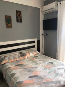 1 dormitorio con 1 cama con edredón en Apartamento Elizabetta 3, pé na areia, en Arraial do Cabo