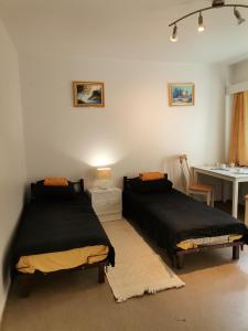 2 camas en una habitación con mesa y escritorio en Budget housing en Kouvola