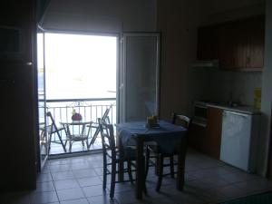 a kitchen with a table and chairs and a balcony at Skiathos city views studios-apartments in Skiathos Town