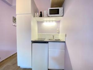 una pequeña cocina con fregadero y microondas en Gallia Bella By SCLS Locations, en Cannes