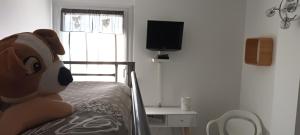 a teddy bear sitting on a bed in a bedroom at Le Queirélé in Le Lavandou