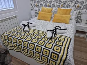 Un dormitorio con una cama con almohadas amarillas y zapatos. en Casa Roman LUX en León