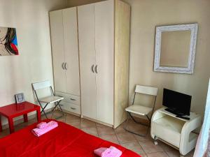 een slaapkamer met een bed, een bureau en een televisie bij Villetta Audrey al Mare in Riccione