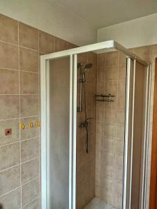 una doccia con porta in vetro in bagno di Villetta Audrey al Mare a Riccione