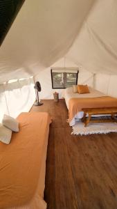 a bedroom with two beds in a tent at Moraycamp in San Andrés de Giles