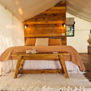 1 dormitorio con 1 cama y pared de madera en Moraycamp en San Andrés de Giles