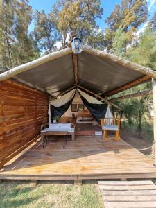 namiot z łóżkiem i 2 krzesłami na drewnianym tarasie w obiekcie Moraycamp w mieście San Andrés de Giles