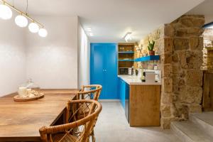 uma cozinha com uma mesa de madeira e uma porta azul em Santorini em Acre