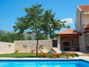 uma piscina com duas cadeiras, uma mesa e uma árvore em Villa Antonija heated private pool, near Dubrovnik,8plus 2 p ideal for families and groups em Cilipi