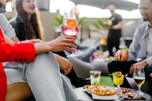 un grupo de personas sentadas alrededor de una mesa con una copa de vino en HF Fenix Porto, en Oporto