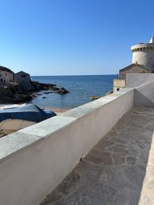 Maison de charme au bout du CAP CORSE في Ersa: جدار حجري بجانب المحيط مع منور