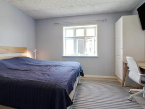 a bedroom with a bed and a desk and a window at Holiday Home Julia - 1-5km from the sea in NW Jutland by Interhome in Skagen