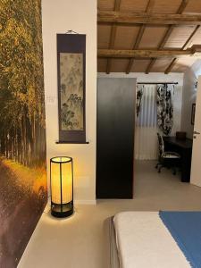 1 dormitorio con 1 cama y 1 lámpara en el suelo en Villa Contessa Massari Ferrara, en Ferrara