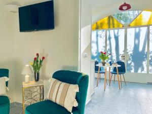 sala de estar con silla azul y mesa en La Dimora 4: Charm and Quiet, en SantʼAgata sui Due Golfi