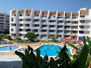 - un grand bâtiment avec une piscine en face dans l'établissement Apartamentos Eurhostal 3000, à Alcossebre