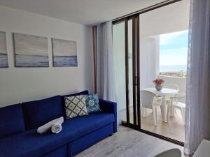 - un salon avec un canapé bleu et une table dans l'établissement Apartamentos Eurhostal 3000, à Alcossebre