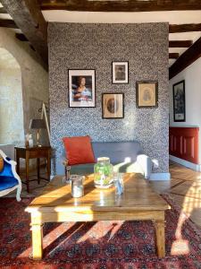 a living room with a table and a couch at Chambre Loulou • Maison Colombage in Provins