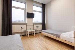 a bedroom with a bed and two windows at BAZZE in Klaipėda