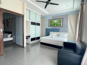 een slaapkamer met een bed, een bank en een plafondventilator bij MR Homestay HotelStyle Room Teluk Intan in Teluk Intan