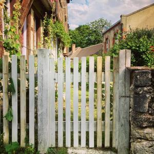 a white picket fence in front of a house at Chambre Loulou • Maison Colombage in Provins